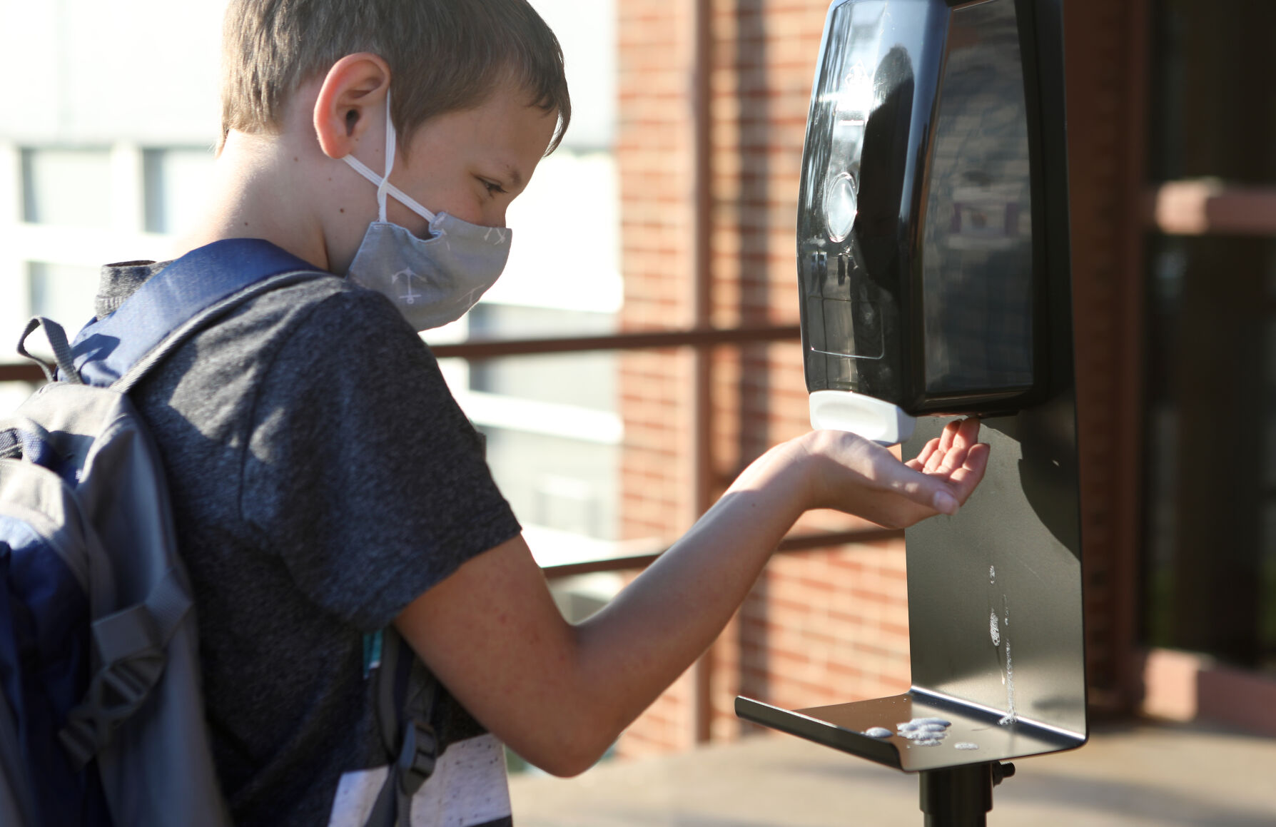 A student gets hand sanitizer